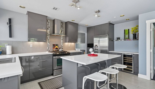 Top-level duplex featuring a sleek open concept kitchen with stainless appliances, cozy fireplace, stylish furnishings, and in-unit washer/dryer. Designed for basking in the sun under skylights in thoughtful details throughout. in Vancouver